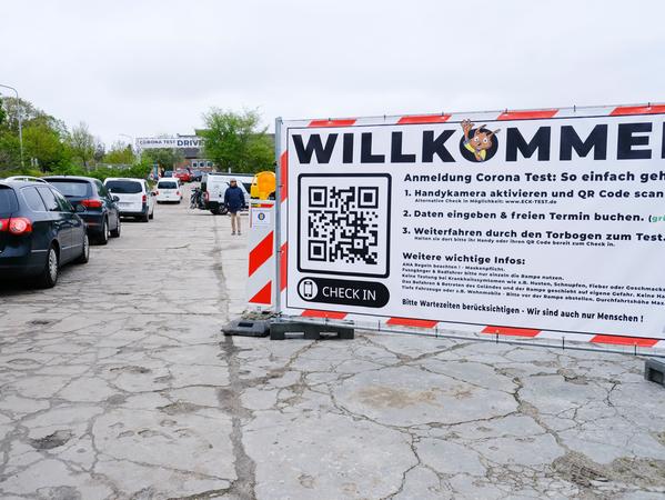 Autos stehen Schlange vor einer Drive-In-Teststation.
Autos stehen Schlange vor einer Drive-In-Teststation.