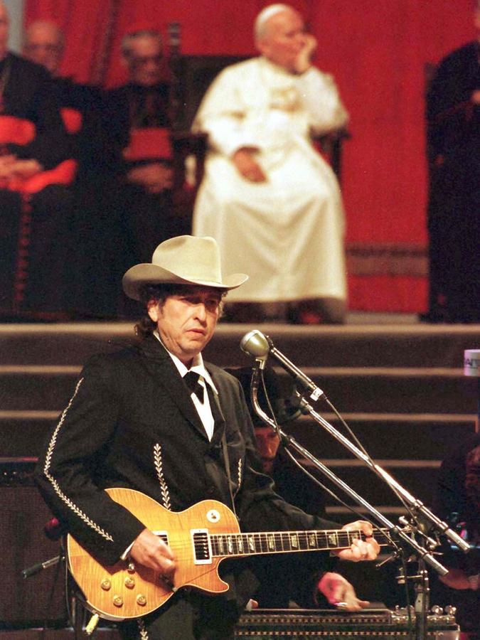 Bob Dylan tritt im Jahr 1997 während eines Kirchenkongresses vor Papst Johannes Paul II. (Hintergrund) auf. Bob Dylan tritt im Jahr 1997 während eines Kirchenkongresses vor Papst Johannes Paul II. (Hintergrund) auf.