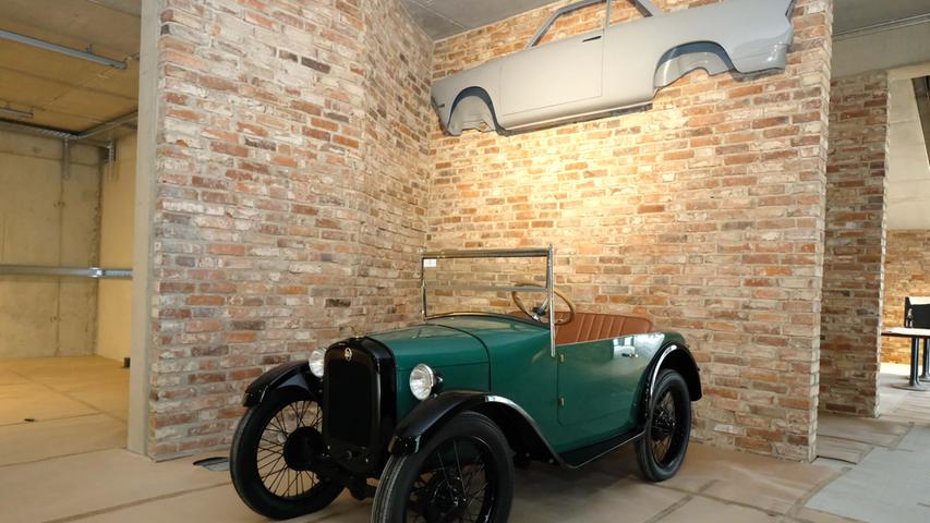 Ein zweisitziges Cabrio aus dem Jahr 1928/29. Präsentiert wird es vor einer Wand aus alten Steinen. 
