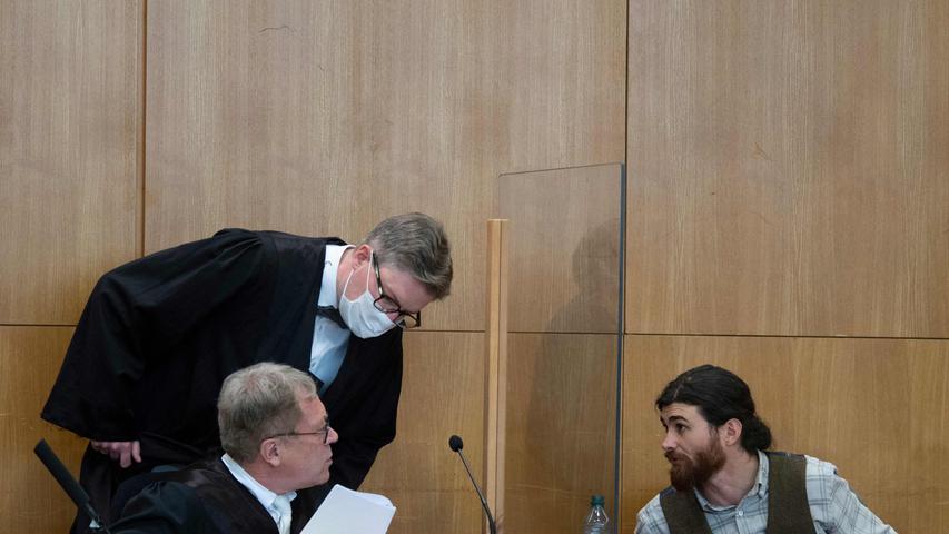 Während des Prozesses spricht Franco A. mit seinen Anwälten Johannes Hock (links, sitzend) und Moritz Schmitt-Fricke.