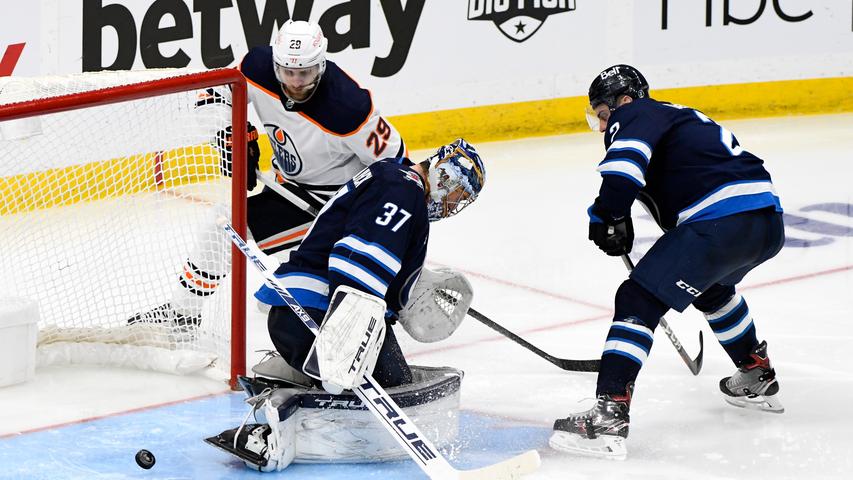 Hängengeblieben: Leon Draisaitl (weißes Trikot) kam mit seinen Edmonton Oilers nicht an den Winnipeg Jets um Keeper Connor Helleybuck und Dylan DeMelo vorbei. In den Playoffs schied das Team des Weltstars nach vier Niederlagen aus.