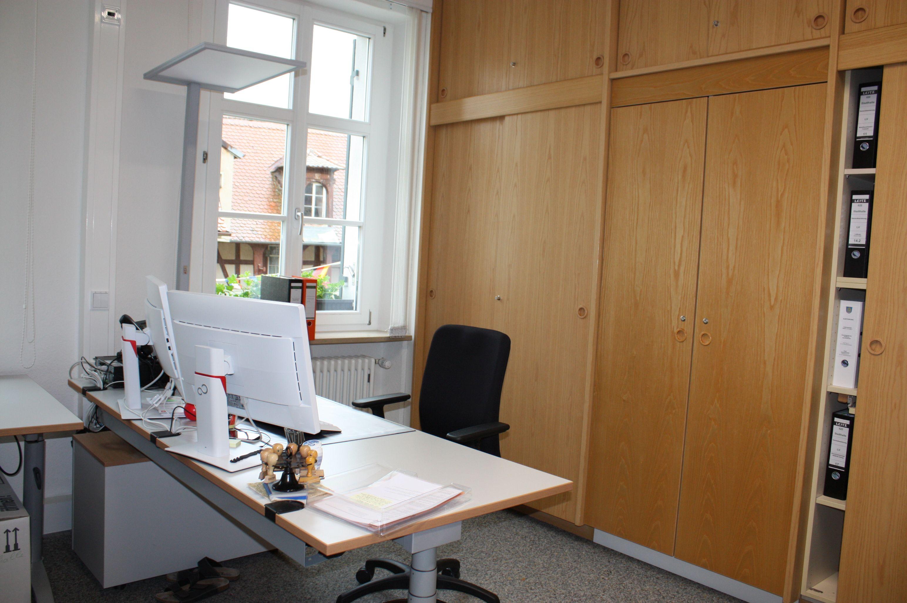 Wo es die Mitarbeiter wollten, wurden die alten Einbauschränke belassen. Die Leiste am neuen, höhenverstellbaren Schreibtisch ist hier optisch auf das Holz des Schranks abgestimmt