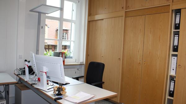 Wo es die Mitarbeiter wollten, wurden die alten Einbauschränke belassen. Die Leiste am neuen, höhenverstellbaren Schreibtisch ist hier optisch auf das Holz des Schranks abgestimmt