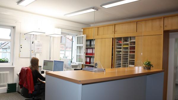 Wo es die Mitarbeiter wollten, wurden - wie hier in der Bauabteilung - die alten Einbauschränke belassen. Neue Elemente, wie etwa der Empfangstresen, wurden optisch auf die Holzschränke abgestimmte.