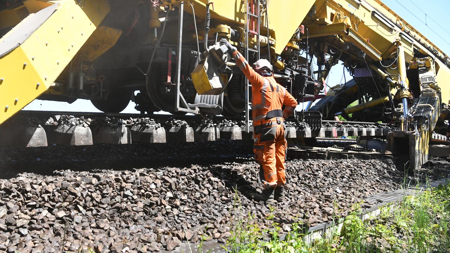 Die Arbeiter überwachen, dass Katharina die Große auch sorgfältig arbeitet. Wenn sie mit der Arbeit fertig ist, kommt ein Schienenlegezug zum Einsatz, der dann Schwellen und Schienen austauschen wird. Die Arbeiter überwachen, dass Katharina die Große auch sorgfältig arbeitet. Wenn sie mit der Arbeit fertig ist, kommt ein Schienenlegezug zum Einsatz, der dann Schwellen und Schienen austauschen wird.