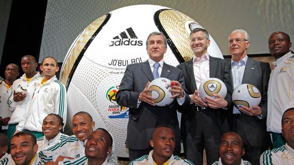 Carlos Pereira, Herbert Hainer und Franz Beckerbauer im Jahr 2010 bei einer adidas-Veranstaltung. Vorne die südafrikanische Nationalmannschaft.