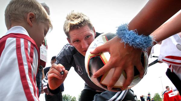 2005: Sebastian Schweinsteiger signiert bei einem öffentlichen Training einen Ball.