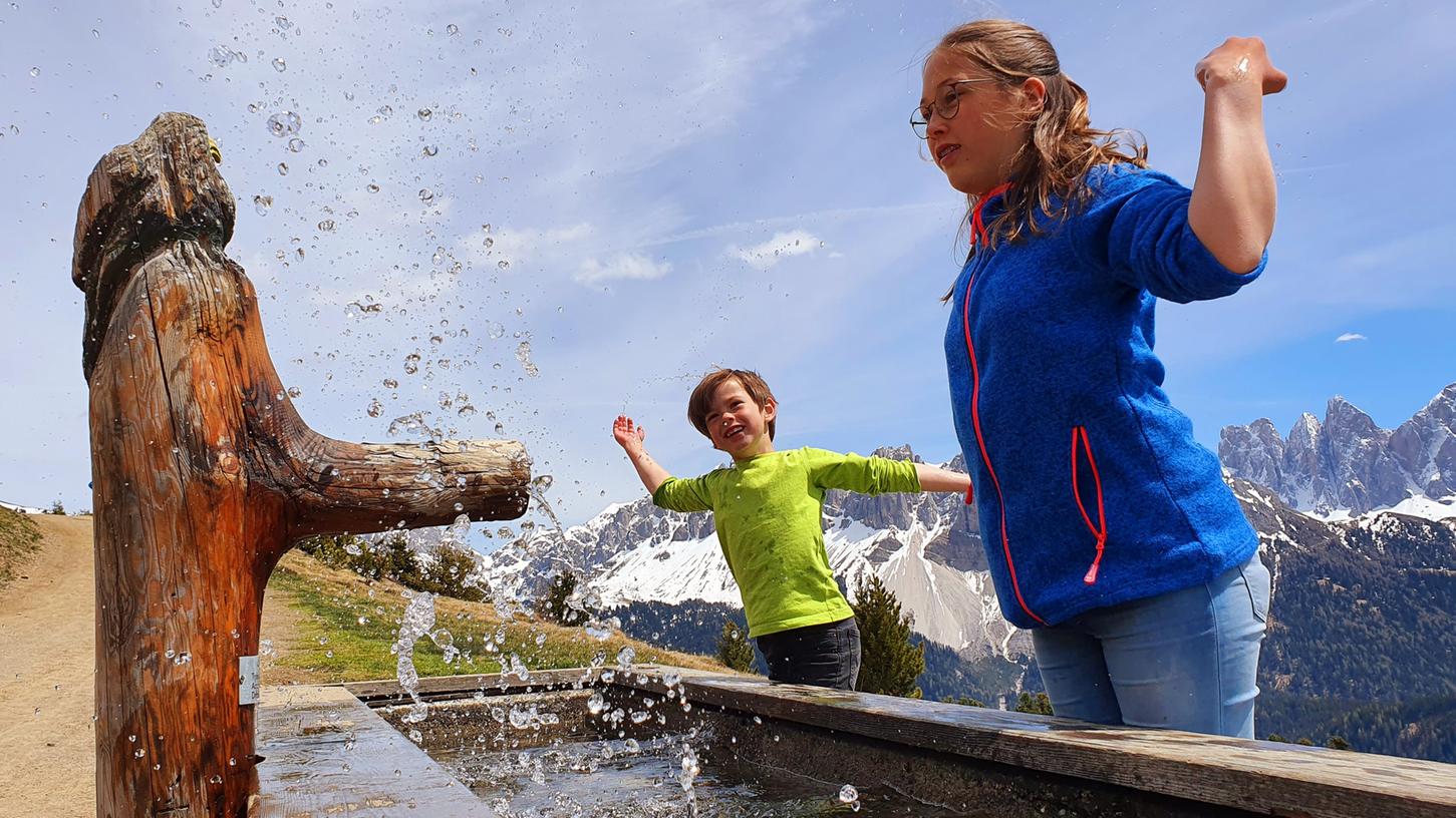 Eine ausgiebige Pause mit Planscheinlage am Wassertrog - so haben Kinder auch beim Wandern ihren Spaß. Hier in Südtirol.