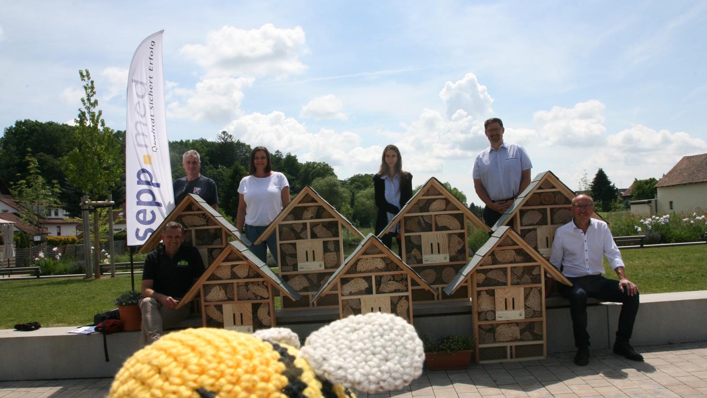 Das symbolische Bienchen im Vordergrund freut sich schon auf die neuen Insektenhotels, die Florian Prester (stehend rechts) an die Vertreterinnen und Vertreter verschiedener Einrichtungen übergeben hat.