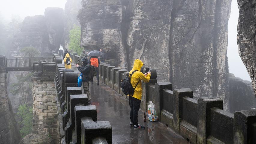 Gerade bei schlechtem Wetter wegen der tollen Stimmung ein Besuch wert: Passanten stehen bei Regen auf der Basteibrücke im Elbsandsteingebirge im Nationalpark Sächsische Schweiz.
Gerade bei schlechtem Wetter wegen der tollen Stimmung ein Besuch wert: Passanten stehen bei Regen auf der Basteibrücke im Elbsandsteingebirge im Nationalpark Sächsische Schweiz.