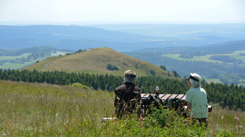 Wanderer genießen bei einer Rast auf der Wasserkuppe den Ausblick über die Rhön.
Wanderer genießen bei einer Rast auf der Wasserkuppe den Ausblick über die Rhön.
