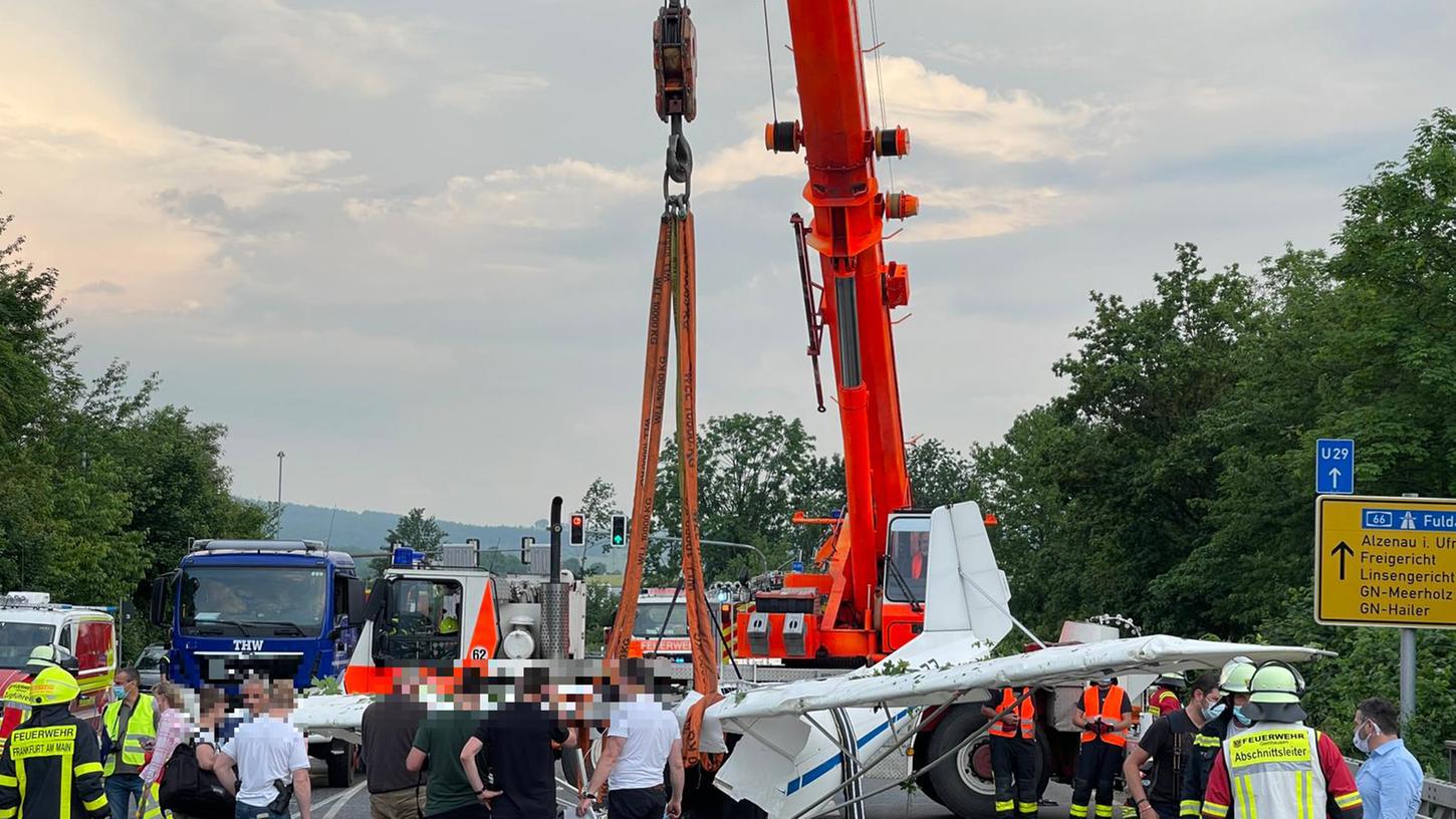 Einsatzkräfte der Feuerwehr haben mit Hilfe eines Krans das Wrack eines abgestürzten Kleinflugzeugs aus der Böschung einer Straße geborgen.