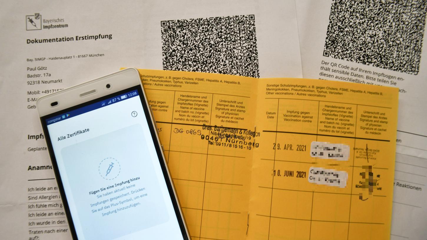 Zwei weiße Zettel beziehungsweise die Einträge im gelben Impfpass kommen als QR-Code in die CovPass-App.
Zwei weiße Zettel beziehungsweise die Einträge im gelben Impfpass kommen als QR-Code in die CovPass-App.
