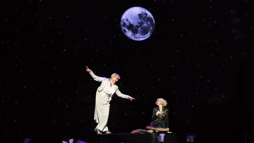 Der Mond leuchtet in Paul Abrahams "Märchen im Grand-Hotel" vor dunklem Hintergrund. Szene mit Jens Janke und Maria-Danaé Bansen.