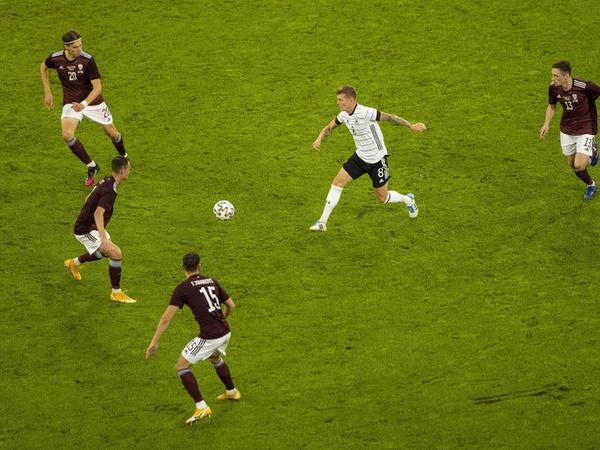 Der Beweis: Toni Kroos spielt den Ball gelegentlich auch nach vorne. Vier Letten schauen staunend zu.
Der Beweis: Toni Kroos spielt den Ball gelegentlich auch nach vorne. Vier Letten schauen staunend zu.
