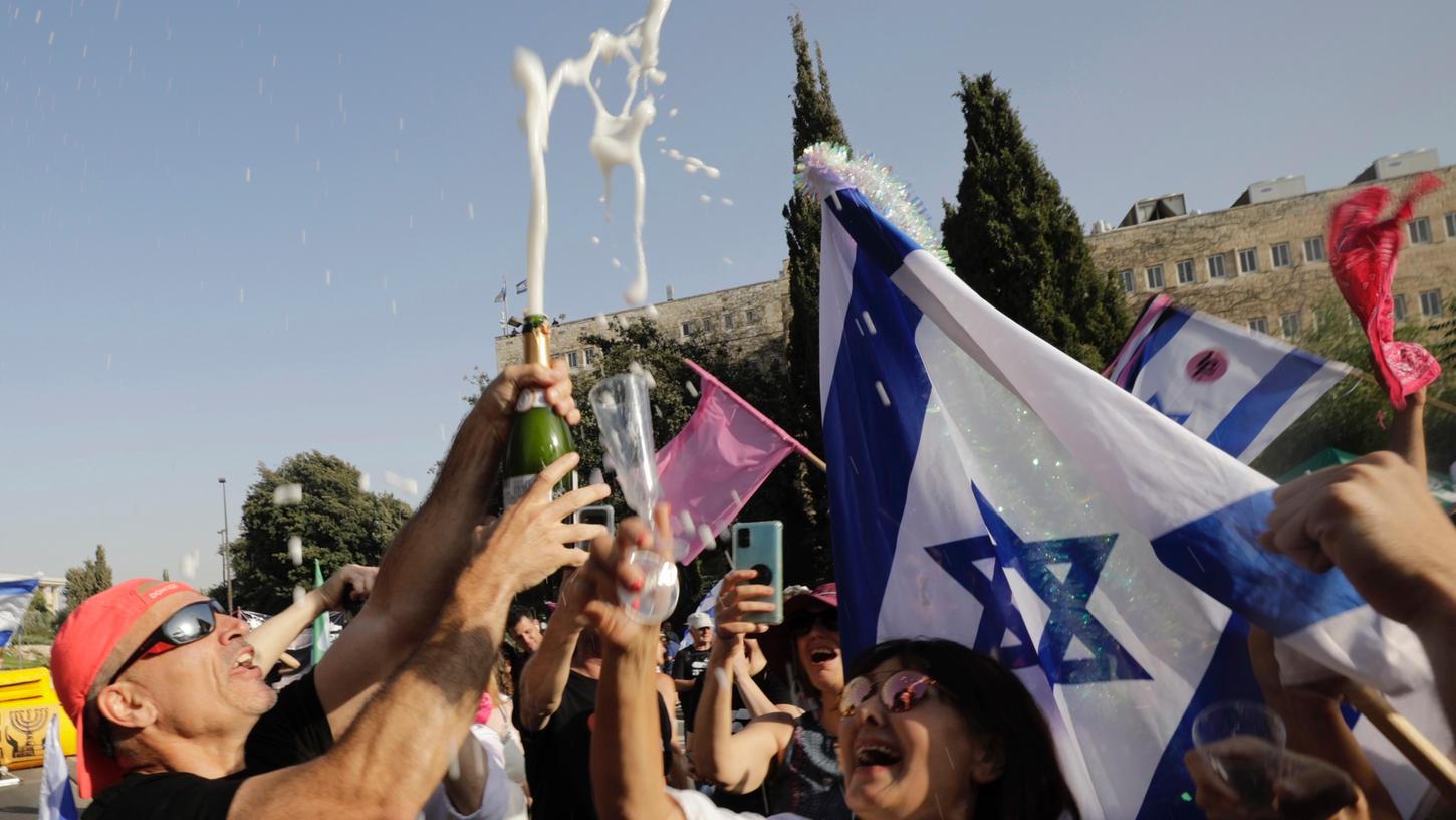 Israelische Demonstranten feiern während einer Demonstration zur Unterstützung der neuen Regierung vor dem israelischen Parlament.
Israelische Demonstranten feiern während einer Demonstration zur Unterstützung der neuen Regierung vor dem israelischen Parlament.