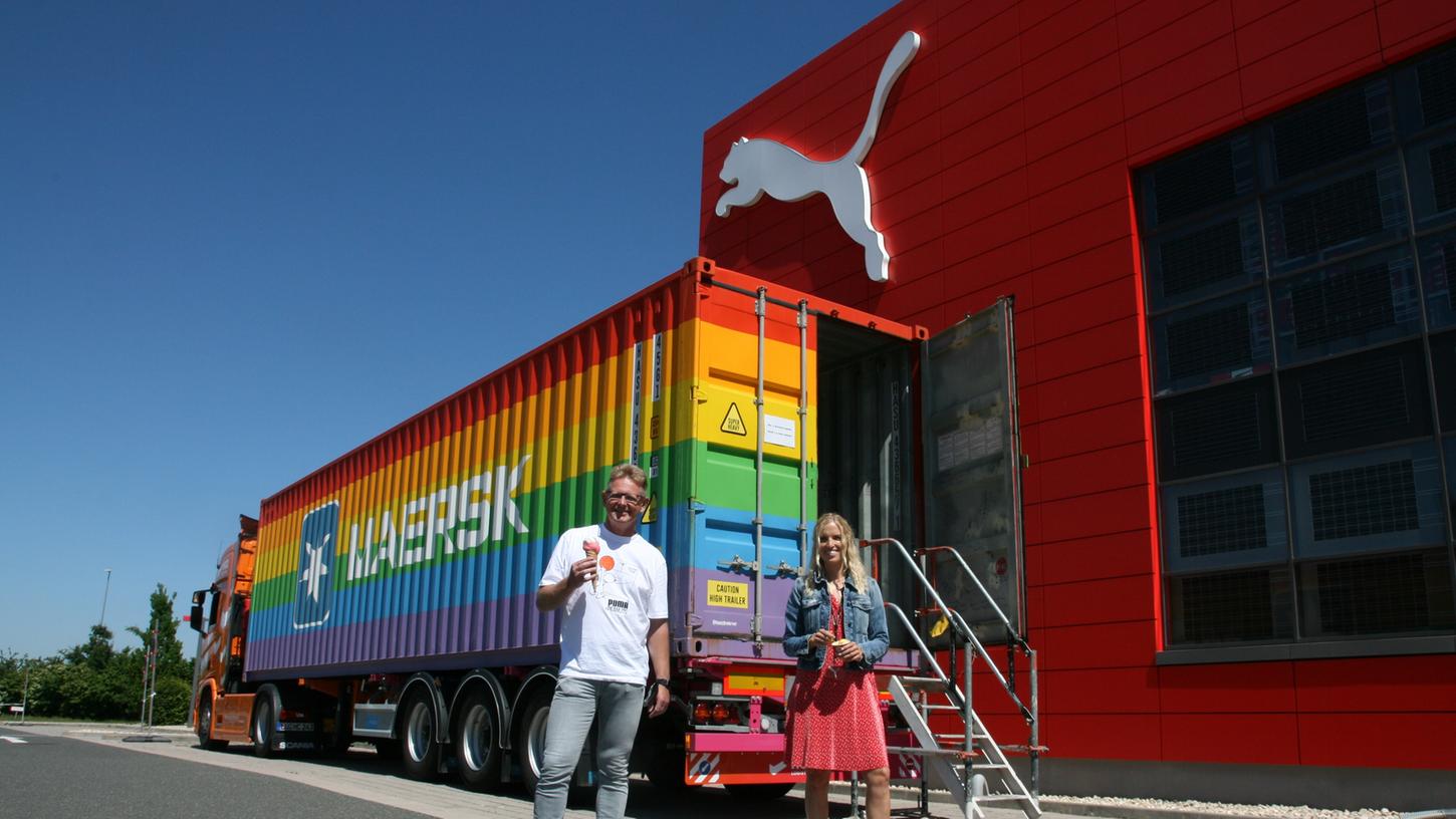 Die Puma-Mitarbeiter Katharina Redelberger und Dietmar Knöß lassen sich vor dem Regenbogen-Container am Puma Store in Herzogenaurach ein buntes Eis schmecken.