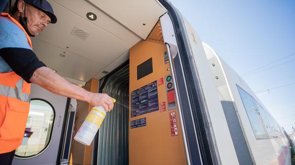 Christian Schmidt, Fahrzeugreiniger, desinfiziert die Türstangen eines ICE im Werk Rummelsburg.