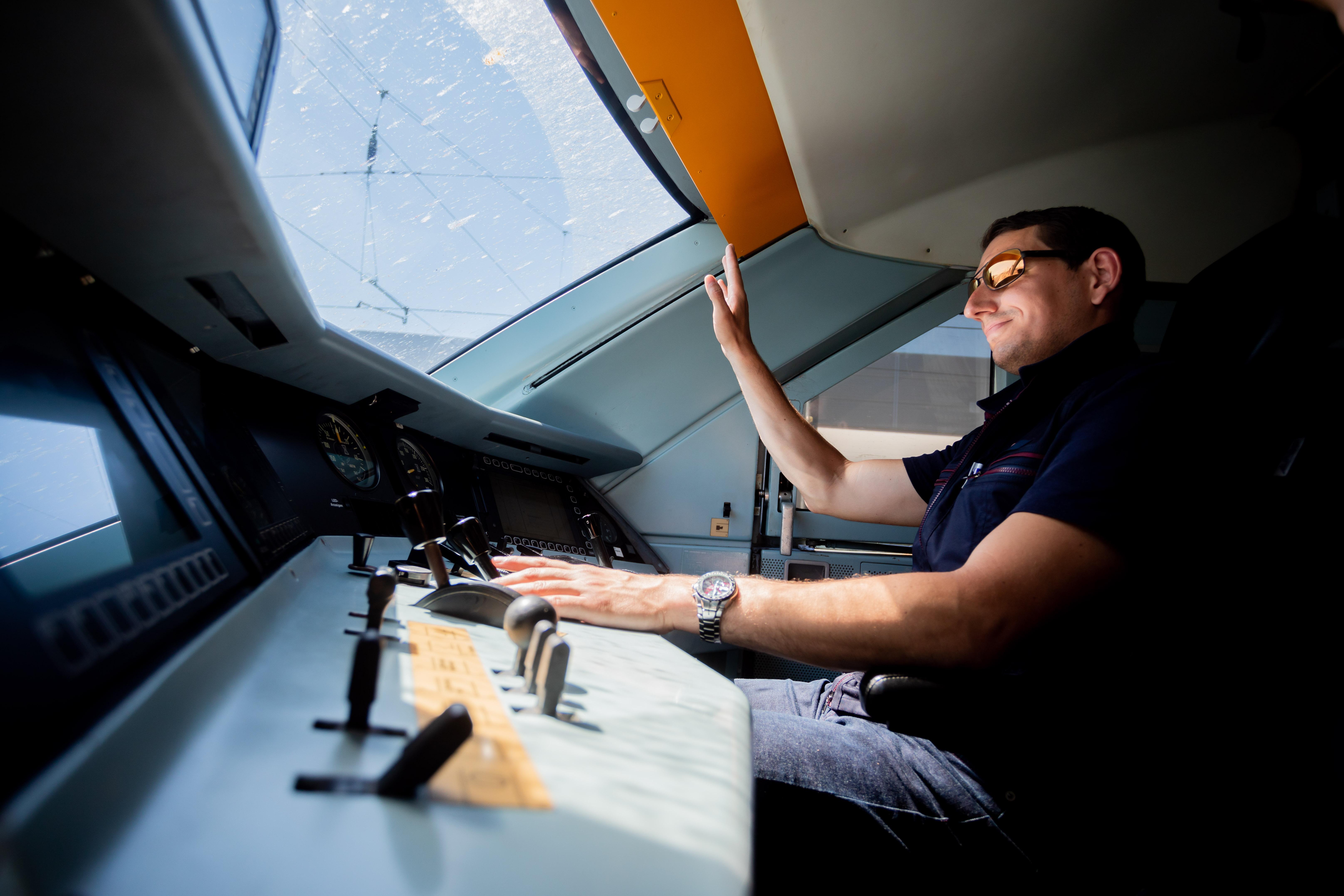 Kevin Tinney, Ausbilder für Lokführer bei der Deutschen Bahn, hebt die Hand, als er einen ICE 2 ins ICE-Werk Rummelsburg fährt. 