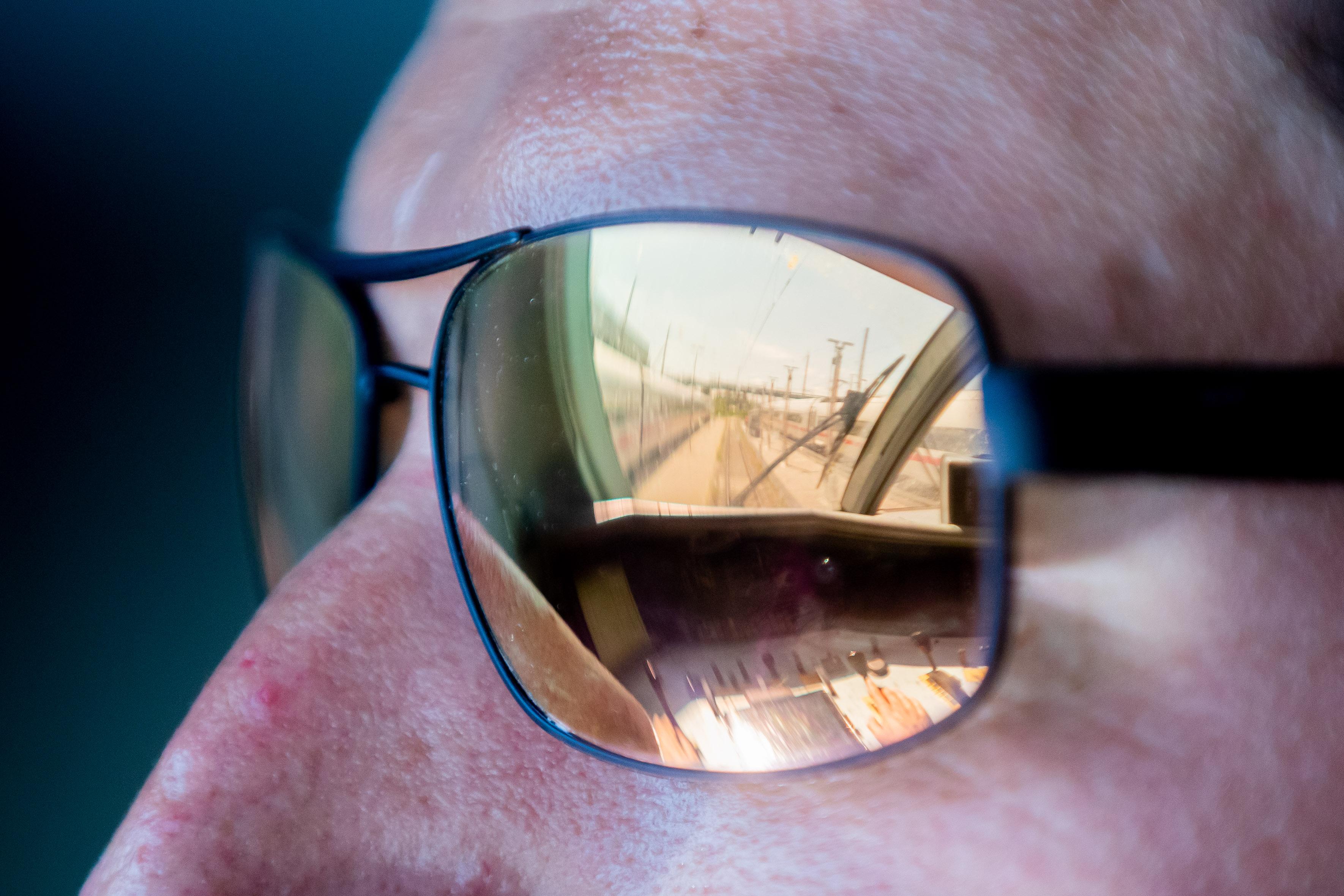 Der Führerstand eines ICE 2 spiegelt sich in der Sonnenbrille von Kevin Tinney, Ausbilder für Lokführer bei der Deutschen Bahn, als dieser den Zug ins ICE-Werk Rummelsburg fährt.