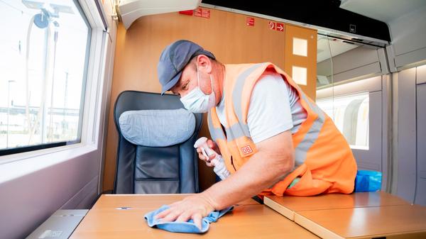 Marcel Ballin, Schichtleiter für die Fahrzeugreinigung, reinigt in einem ICE einen Tisch, als dieser im ICE-Werk Rummelsburg zur Reinigung Zwischenhalt macht.