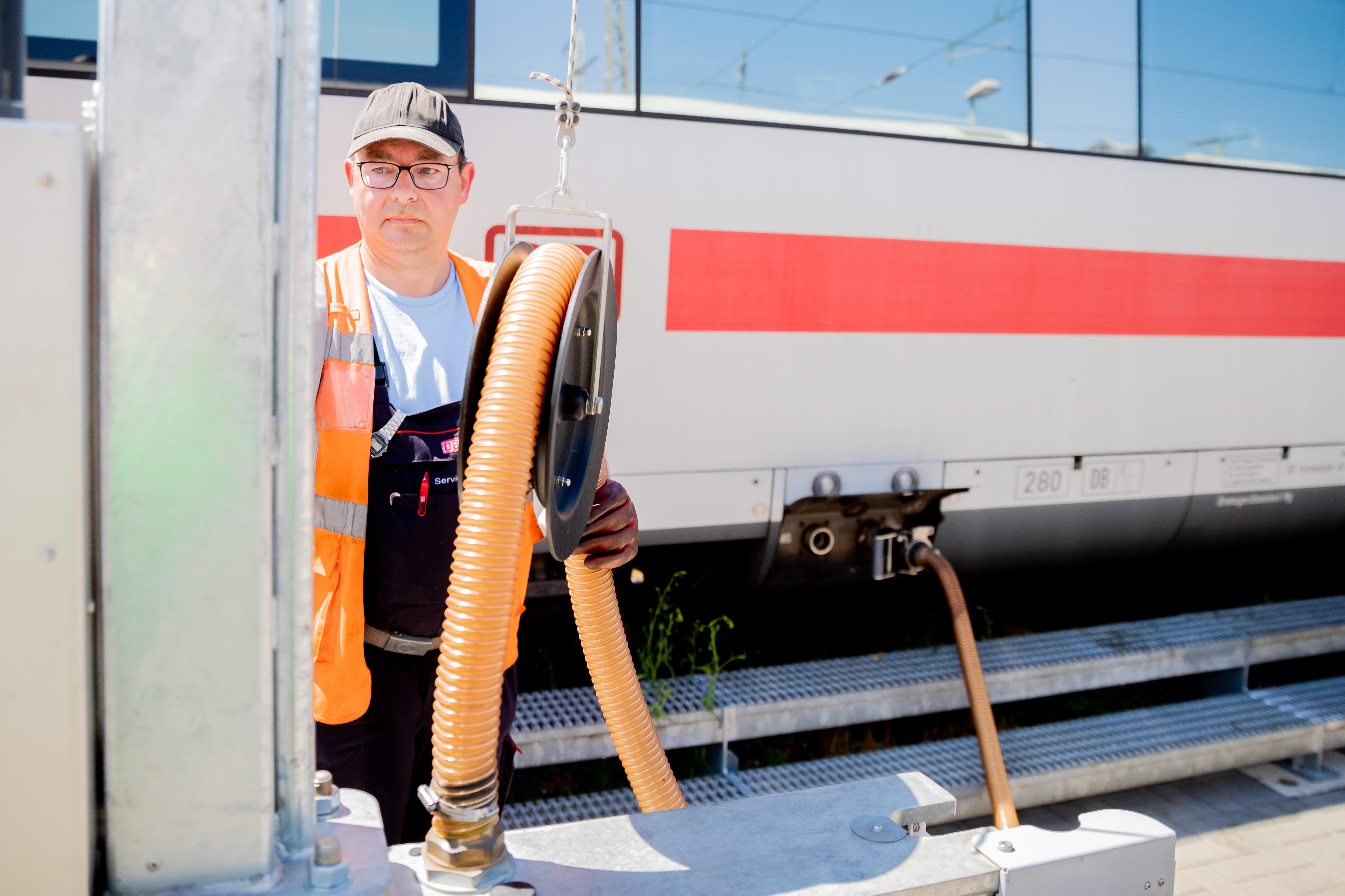 Sven Heßler, Fahrzeugreiniger, saugt Abwässer aus einem ICE, als dieser im ICE-Werk Rummelsburg zur Reinigung Zwischenhalt macht.