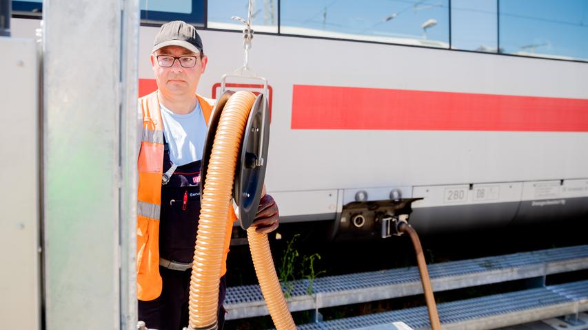 Sven Heßler, Fahrzeugreiniger, saugt Abwässer aus einem ICE, als dieser im ICE-Werk Rummelsburg zur Reinigung Zwischenhalt macht.