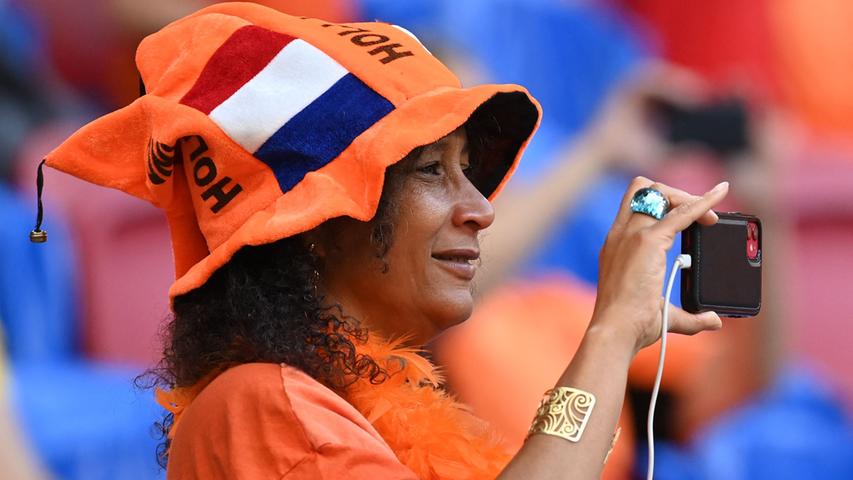 A supporter of Netherlands carries her phone ahead of the UEFA EURO 2020 Group C football match between the Netherlands and Ukraine at the Johan Cruyff Arena in Amsterdam on June 13, 2021. (Photo by JOHN THYS / POOL / AFP)