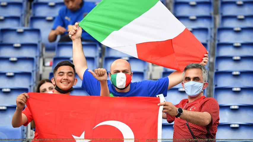 Italy and Tuekey fans pose with their flags as they wait for the start of the UEFA EURO 2020 Group A football match between Turkey and Italy at the Olympic Stadium in Rome on June 11, 2021. (Photo by Filippo MONTEFORTE / POOL / AFP)