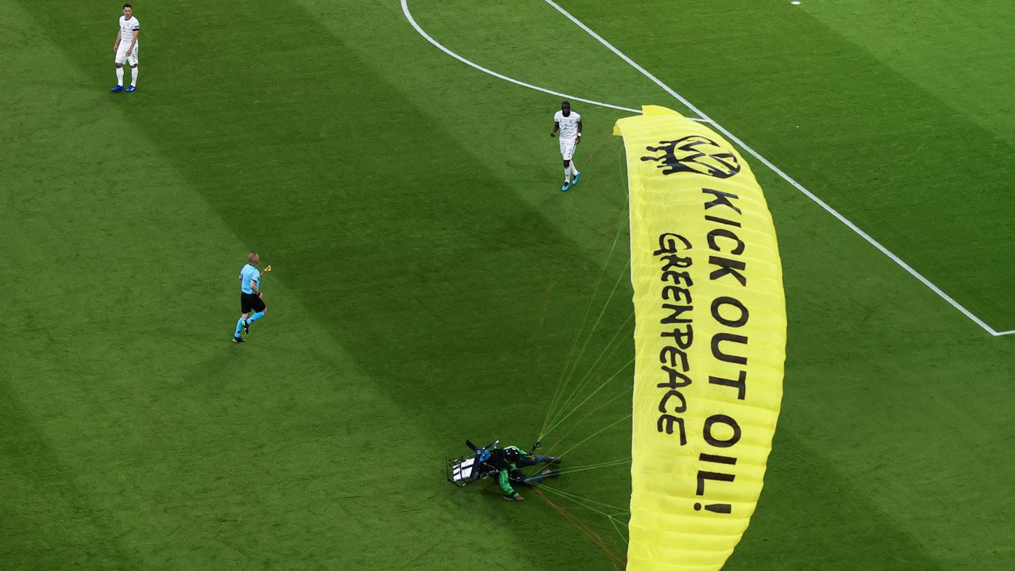 Ein Greenpeace-Aktivist muss kurz vor Anpfiff des EM-Spiels zwischen Deutschland und Frankreich mit einem Motorschirm mitten im Stadion notlanden.