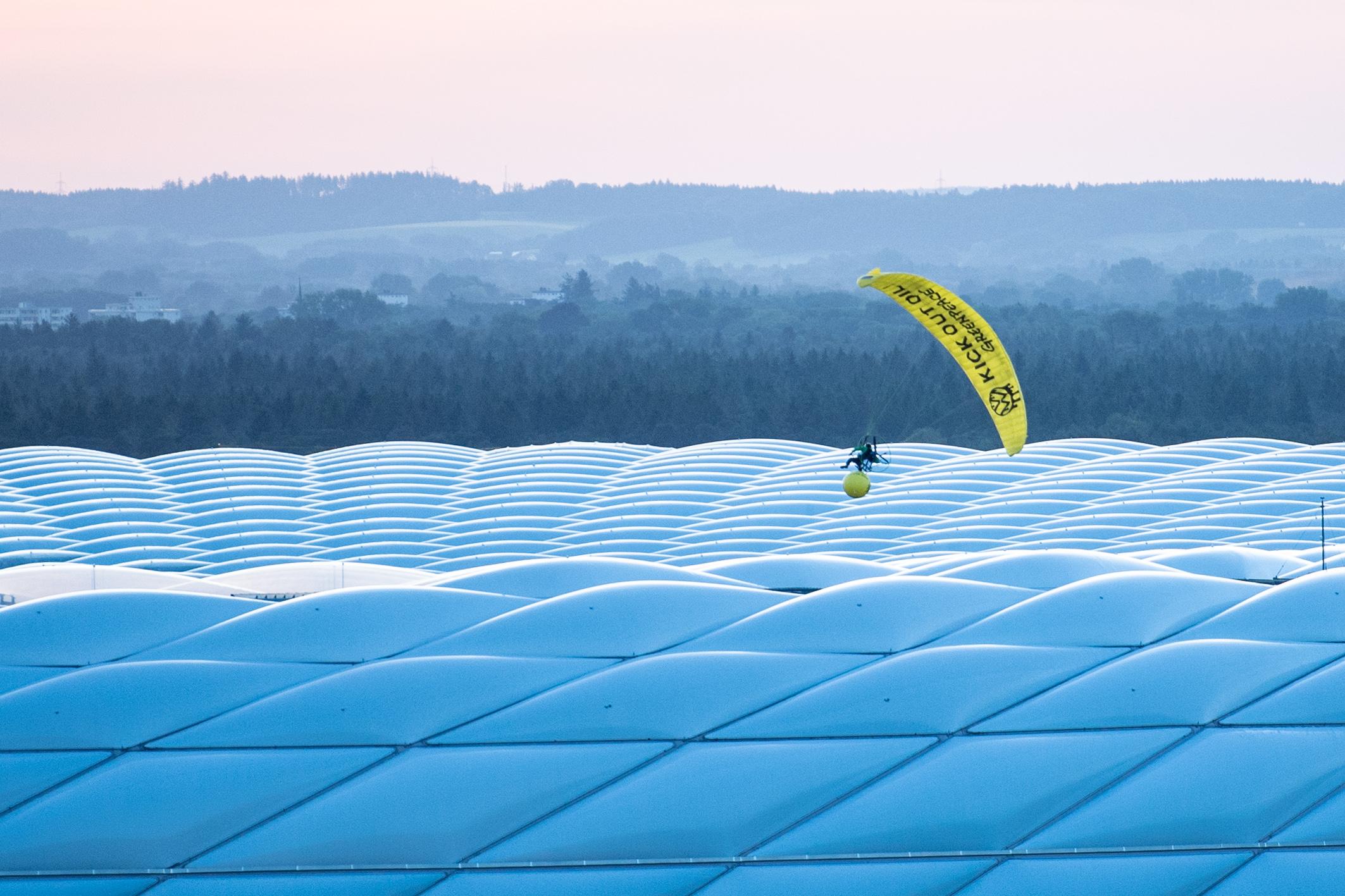 Am Dienstagabend schwebte ein Mann über der Allianz Arena und versuchte, einen großen gelben Ball ins Stadion zu werfen. Am Dienstagabend schwebte ein Mann über der Allianz Arena und versuchte, einen großen gelben Ball ins Stadion zu werfen.