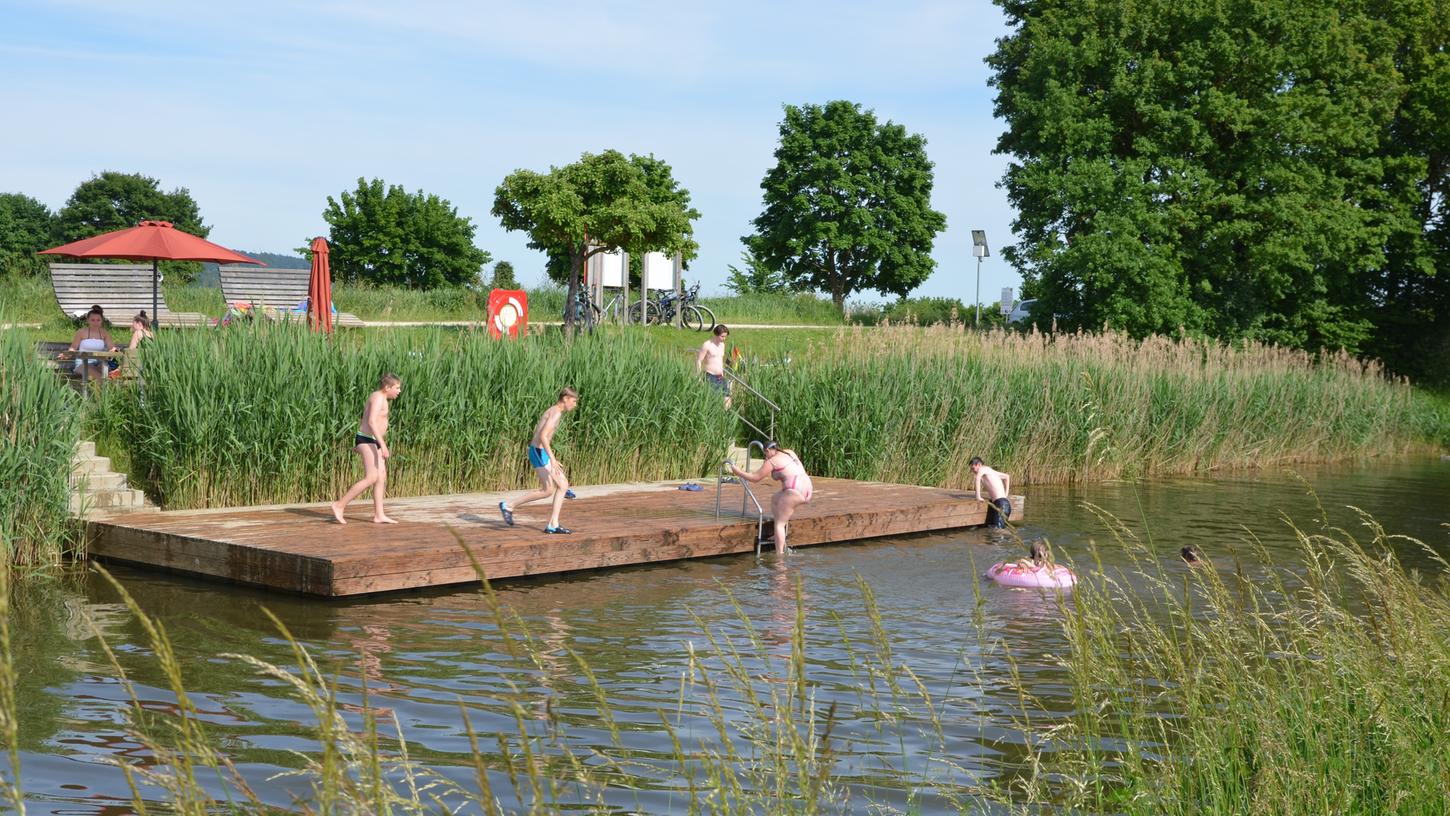 Ein vergnügtes Treiben an der Kanalbadestelle „Röthbrücke“ bei Berg. Nicht nur zahlreiche Kinder haben ihren Spaß, auch Stockschützen und Radlfahrer vom „Fünf-Flüsse-Radweg“ machen dort gerne Halt. Ebenso das Schwanenpaar mit ihrem Nachwuchs, welche dem Treiben neugierig zusehen und mit „Schwanengesang“ honorieren.