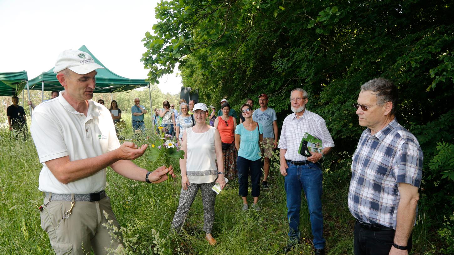 Der Bund Naturschutz hat eine bedeutende Orchideen-Wiese in Nürnberg gekauft. BN-Geschäftsführer Wolfgang Dötsch BN (links) erklärt BN-Chef Otto Heimbucher (rechts) und vielen Förderern die Flora.