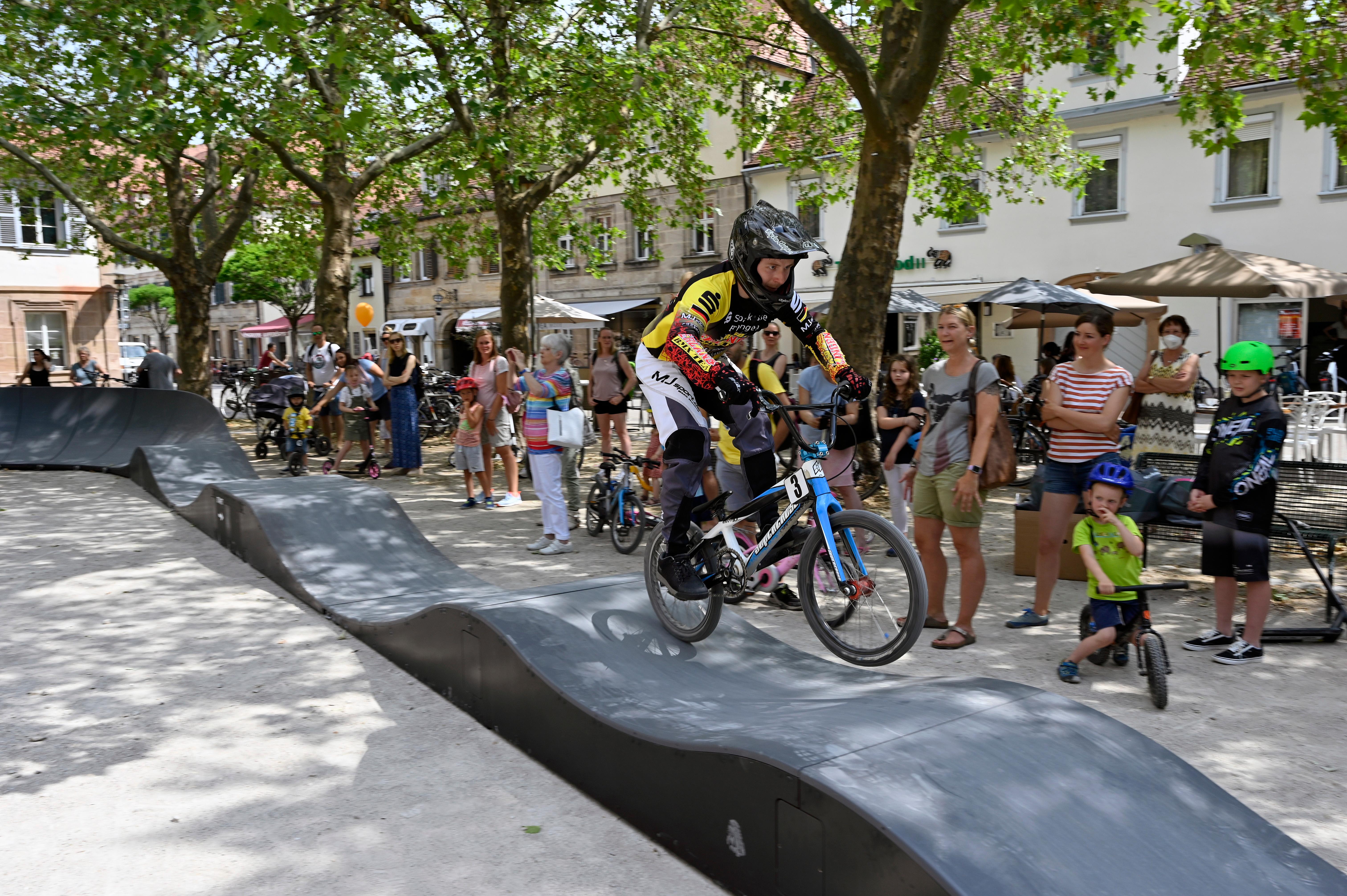 Seit Samstag hat sich der Neustädter Kirchenplatz in ein Paradies für kleine und große Roller-, BMX- und Skateboardfahrer verwandelt. Da wurde in der Erlanger Innenstadt der mobile Fun-Track eröffnet. Nachdem die Sportlerinnen und Sportler des BMX-Teams des RC 50 Erlangen eine kleine Showvorführung gegeben hatten, wurde er der Öffentlichkeit freigegeben – und wurde, wie auf dem Bild zu sehen ist, sofort ausgiebig genutzt. Die Benutzung des Fun-Tracks ist kostenlos, noch bis einschließlich 4. Juli steht er auf dem Neustädter Kirchenplatz. Danach soll er in den Stadtwesten ziehen. 