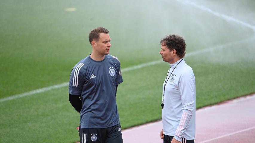 Torwart Manuel Neuer und Trainer Marcus Sorg unterhalten sich vor dem Training.