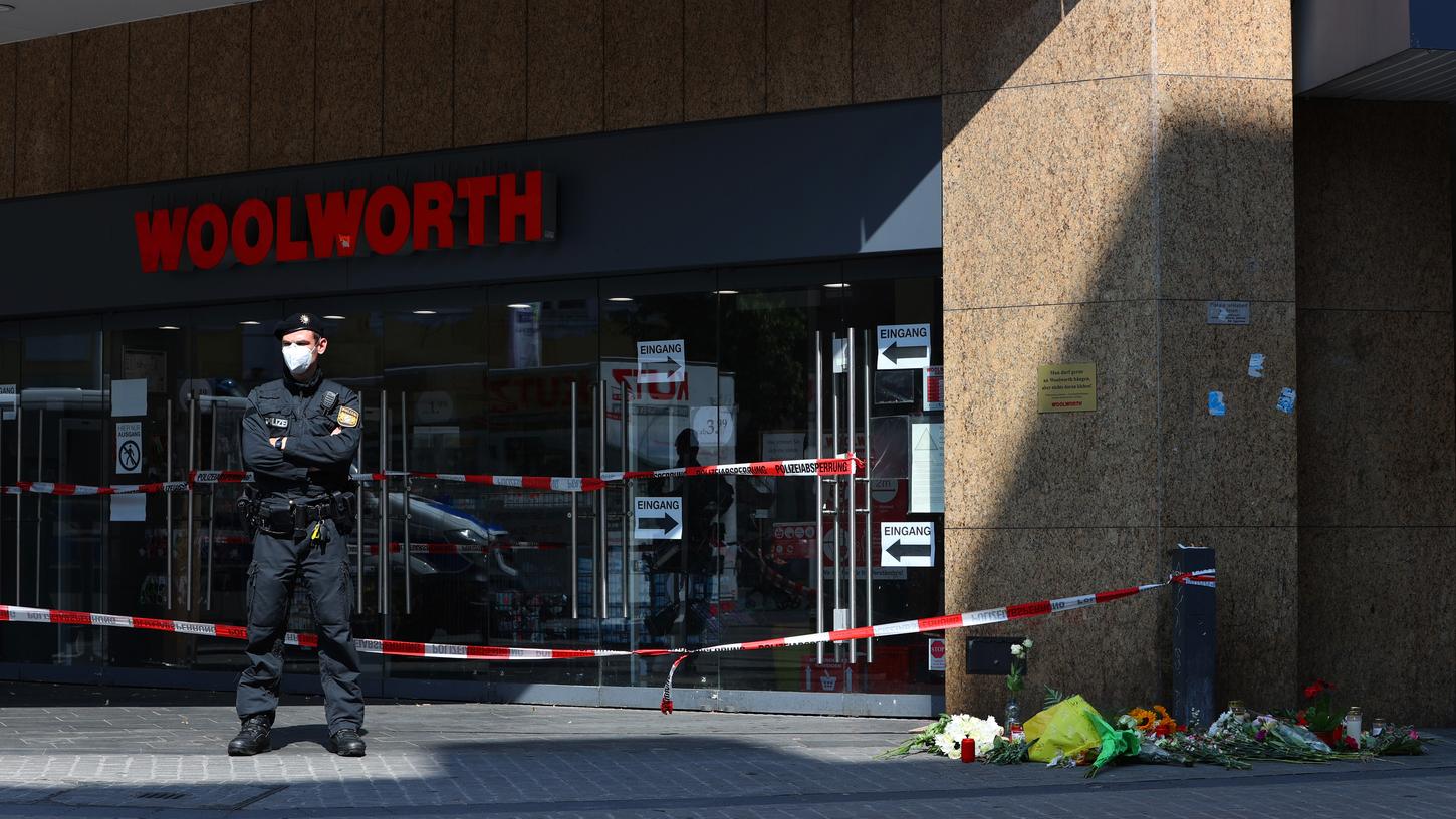Ein Polizist steht am Tag nach den tödlichen Messerangriffen vor dem Eingang eines Würzburger Kaufhauses. Dort starben drei Menschen.
