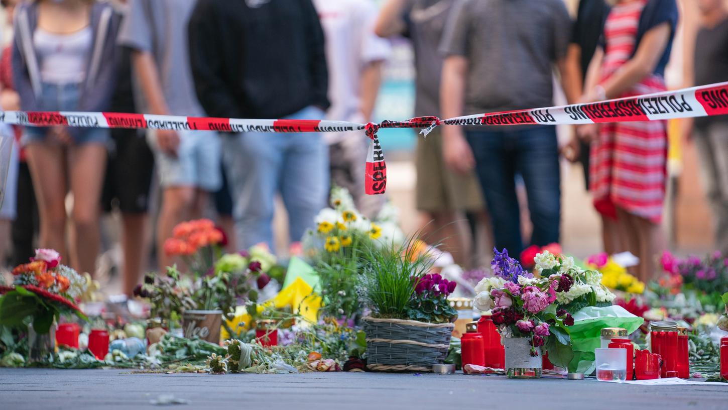 Trauerkerzen und Blumen liegen vor einem Kaufhaus in der Innenstadt, in dem ein Mann Menschen mit einem Messer attackiert hatte.
