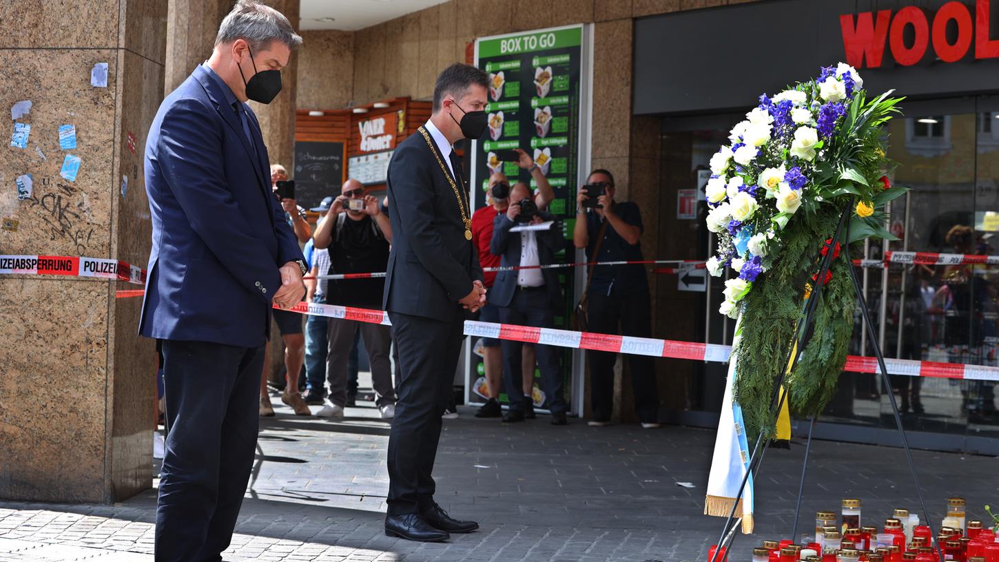 Markus Söder (CSU, l), Bayerns Ministerpräsident, und Christian Schuchardt (CDU), Oberbürgermeister von Würzburg, gedenken in der Innenstadt der Opfer einer Messerattacke.