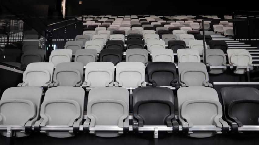 Die Stühle auf den Tribünen sind in weiß, grau und dunkelgrau gehalten. Das hat einen Grund: Sitzschalen in knalligen Farben sind bei Fernsehübertragen oft ein Problem.