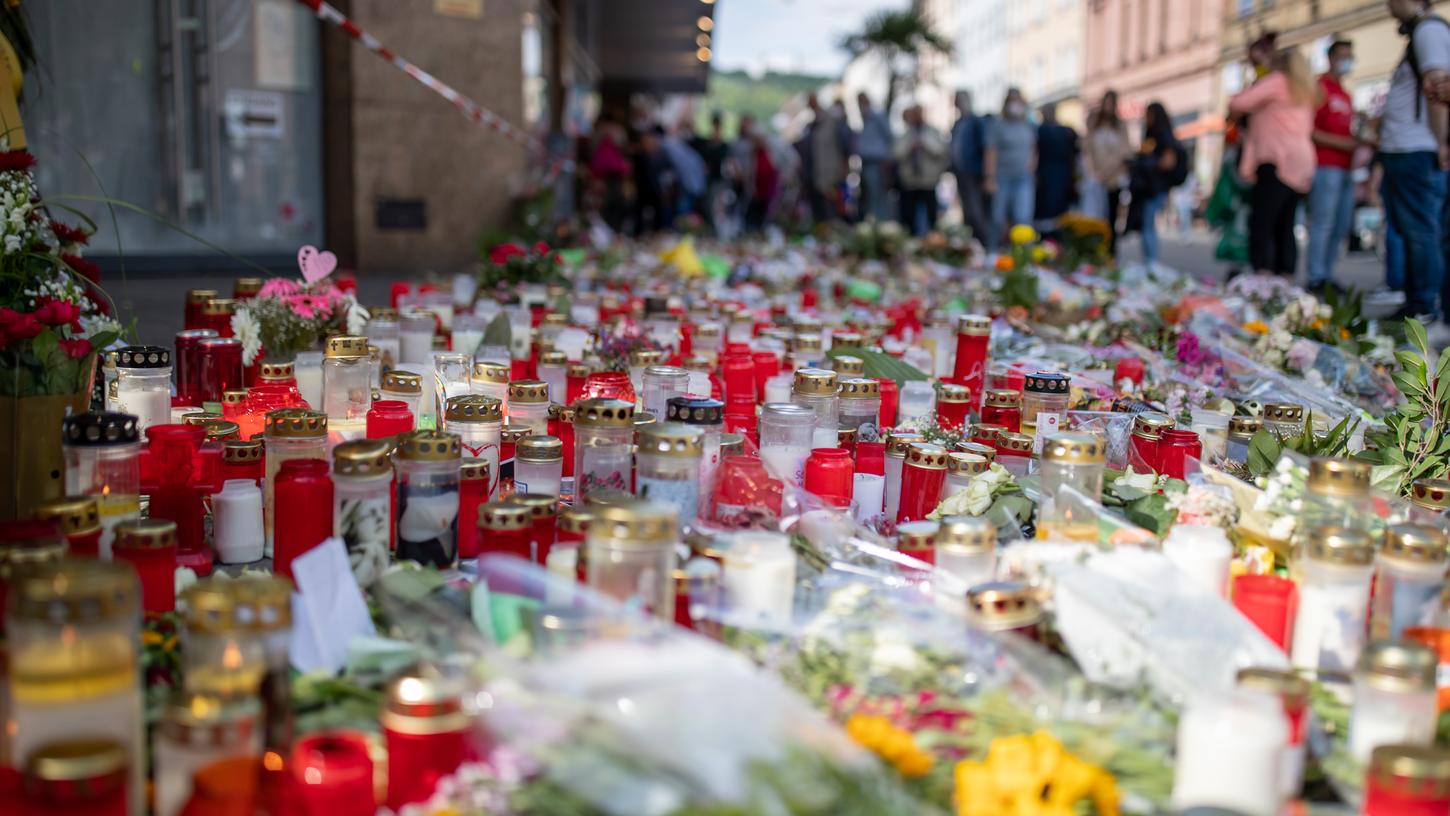 Grablichter, Kerzen und Blumen liegen vor einem Kaufhaus in der Würzburger Innenstadt, in dem ein Mann vor zwei Wochen Menschen mit einem Messer attackiert und getötet hatte.