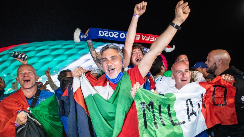 Fans der italienischen Fußball-Nationalmannschaft feiern den Sieg vor dem beleuchteten Stadion. In einem spannenden Spiel hatten sich die Italienern am Freitagabend gegen starke Belgier mit einem 2:1 durchgesetzt. Italien steht damit im Halbfinale. 