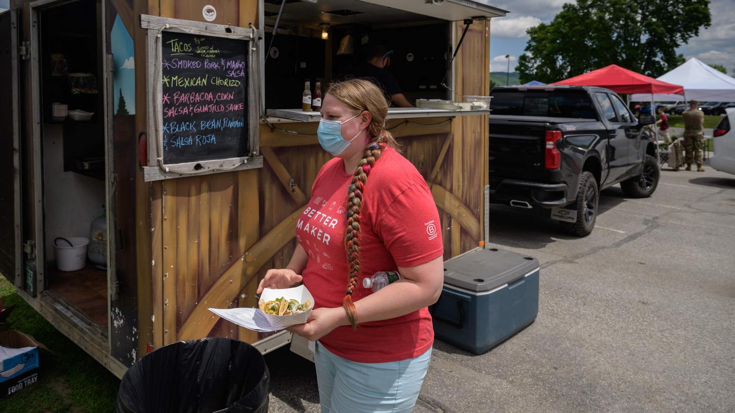 Im US-Bundestaat Vermont holt sich diese Frau einen kostenlosen Taco ab: eine kleine Dreingabe dafür, dass sie sich an einem Pop-Up-Impfstand gegen Covid-19 hat immunisieren lassen. Im US-Bundestaat Vermont holt sich diese Frau einen kostenlosen Taco ab: eine kleine Dreingabe dafür, dass sie sich an einem Pop-Up-Impfstand gegen Covid-19 hat immunisieren lassen.