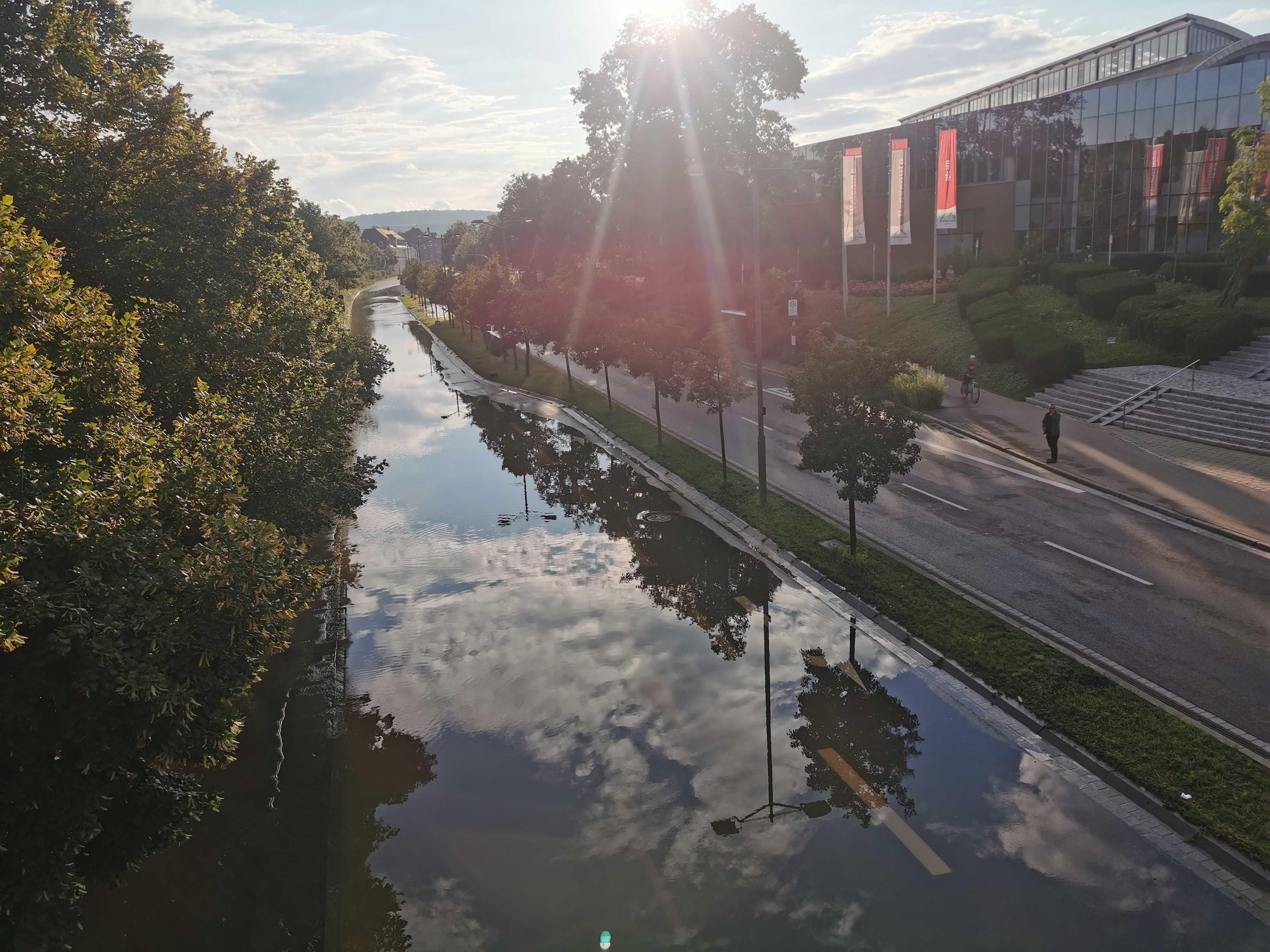 Am Brückencenter läuft das Wasser der Rezat bereits über die Straße. Die Kreuzung war am Abend für mehrere Stunden komplett gesperrt. Dadurch kam es zu einem größeren Verkehrschaos in Ansbach.