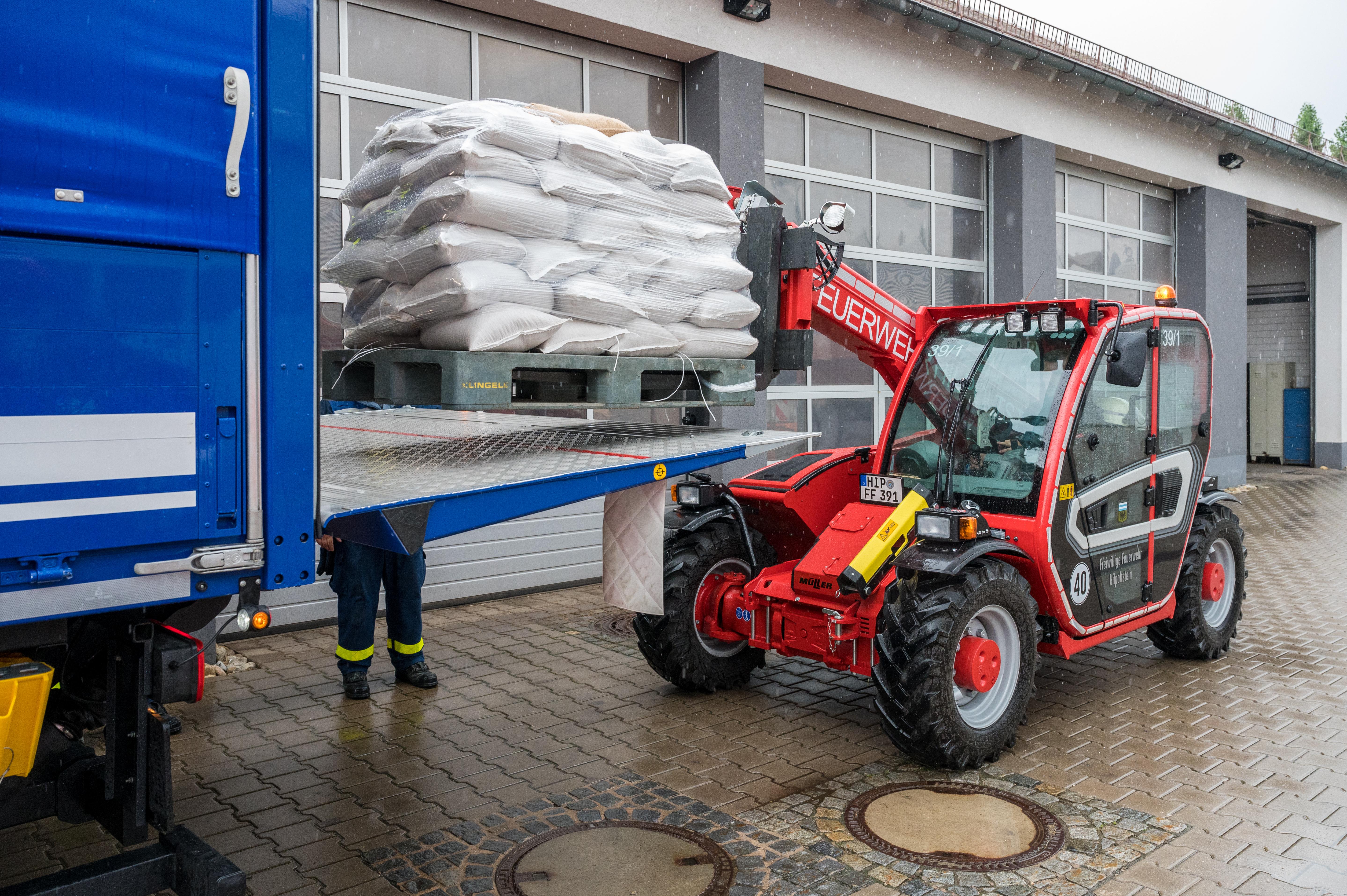 Sandsäcke werden zum Weitertransport in THW-Lkw verladen.