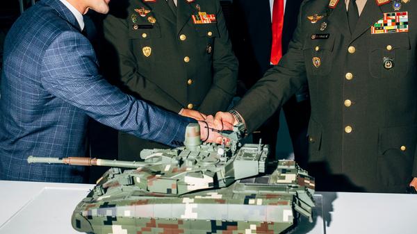 Ein ukrainischer Aussteller schüttelt die Hand einer peruanischen Delegation auf der SITDEF in Lima (Peru) im Mai 2019. Die SITDEF gilt als Präsentationsplattform der neuesten Technologien des internationalen Marktes zur Abwehr, Sicherheit und Prävention von Naturkatastrophen. Der prämierte Fotograf Nikita Teryoshin besuchte zahlreiche Waffenmessen, um sich ein Bild vom weltweiten Waffenhandel machen zu können. Seine Bilder waren am Samstag bei der Fotoausstellung von Greenpeace zu sehen. Die Kritik der Aktivistinnen und Aktivisten lautet: Als weltweit viertgrößter Waffenexporteur trage Deutschland eine Mitverantwortung für Krisenherde und Waffenmissbrauch.