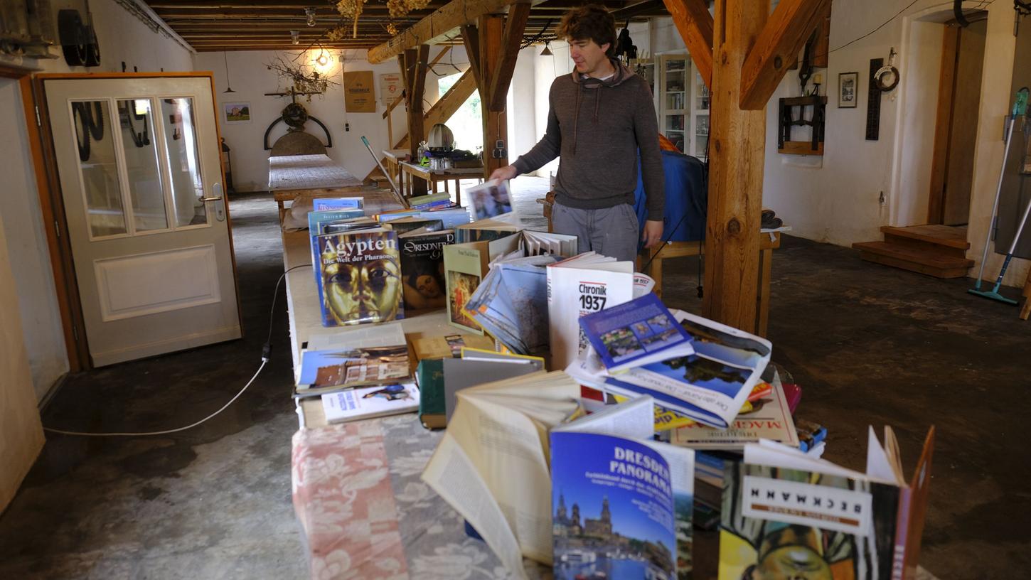 Norbert Ortegel von der Greienmühle bei Höchstadt stellt Bücher zum Trocknen auf. 