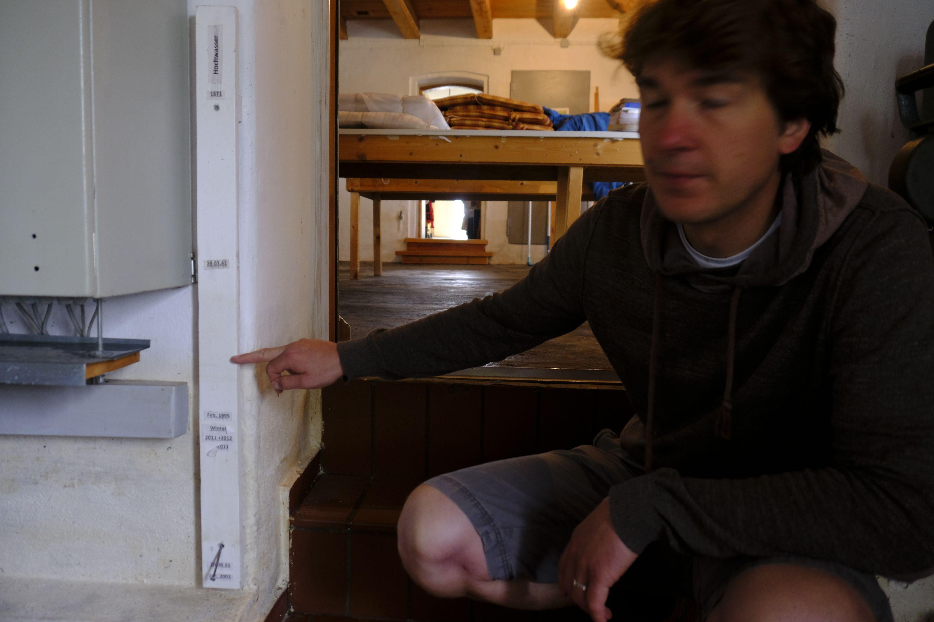 Norbert Ortegel deutet auf die Wasserlinie vom Vortag. Höher war nur ein Hochwasser 1941 und 1871.