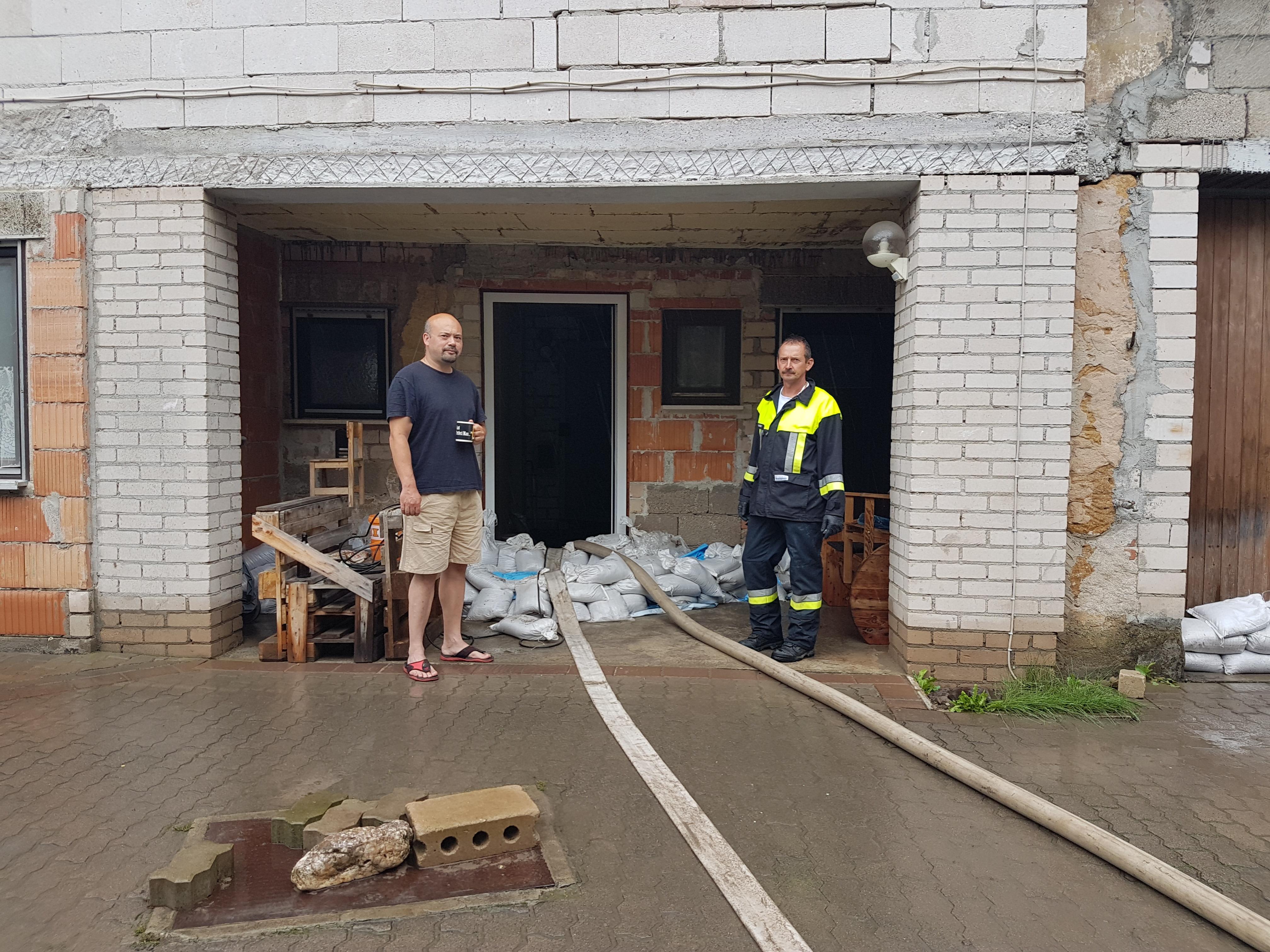 Oliver Lotze mit Feuerwehrmann: Wasser im Hof und Treppenhaus in Hallerndorf.