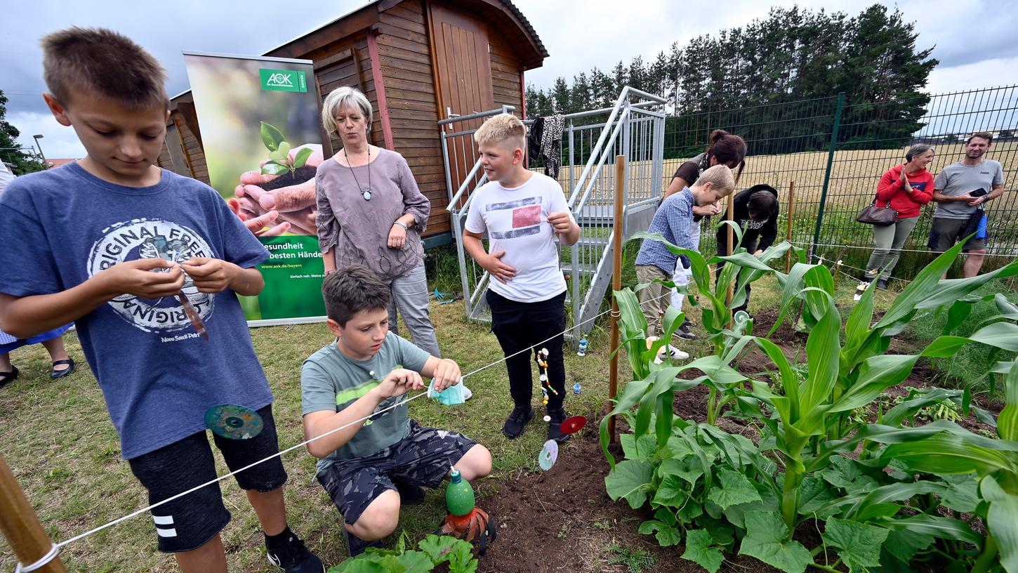 Fünftklässler am Emmy-Noether-Gymnasium bestellen bei der "GemüseAckerdemie" einen Acker auf dem Schulgelände. Zum Schutz vor Vögeln und Hasen hängen sie selbst Gebasteltes zwischen die Beete.