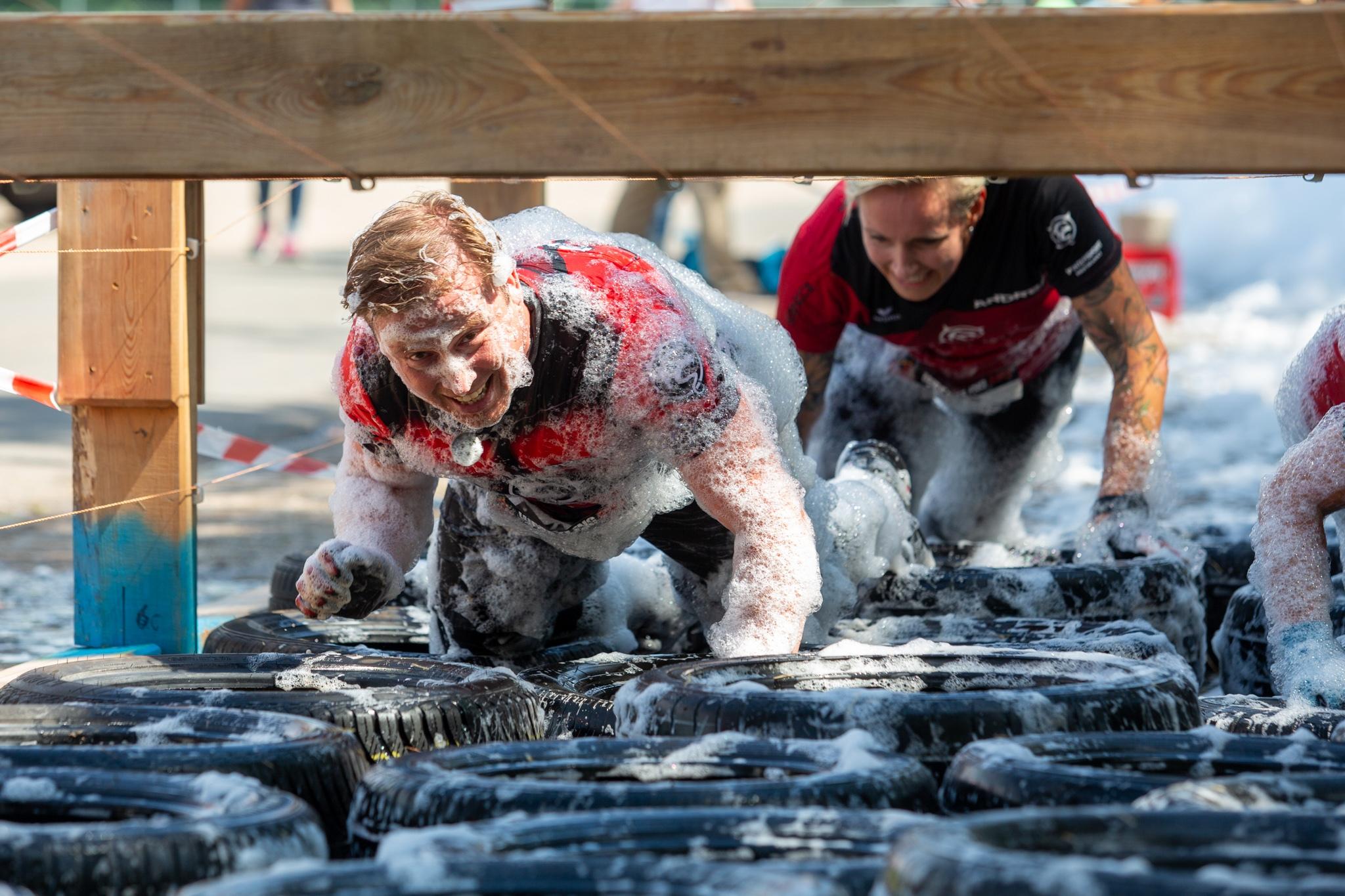 Frisch eingeseift, robbt dieser Teilnehmer durch Autoreifen.
